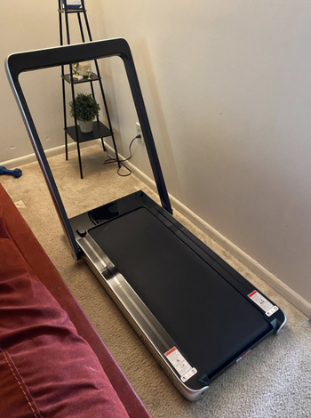 Reviewer's folded treadmill open and ready to use in their bedroom