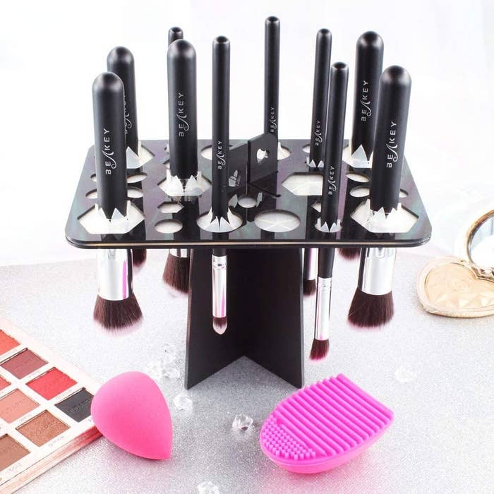 A drying rack filled with makeup brushes