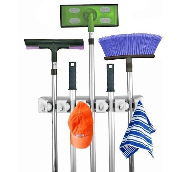 wall mount holding various cleaning supplies and a hat