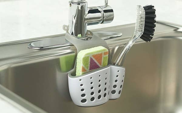 sink caddy attached to faucet holding a sponge and a scrubber brush