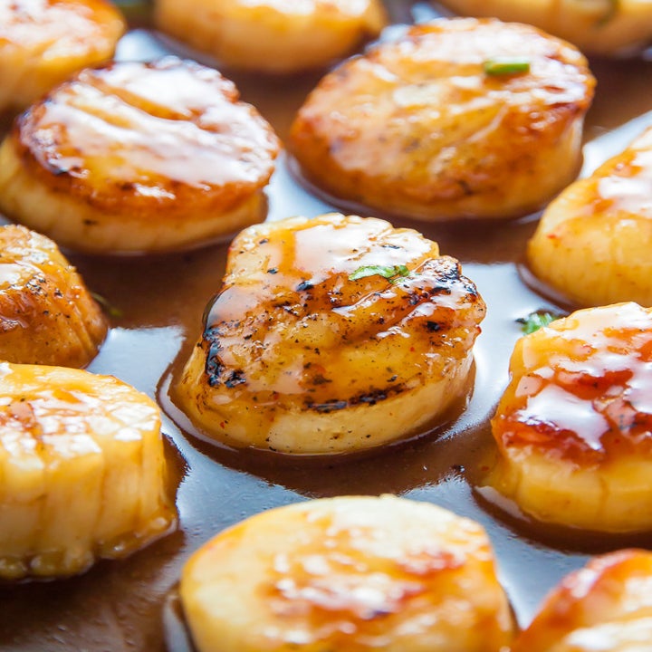 Glazed scallops cooking in a pan.