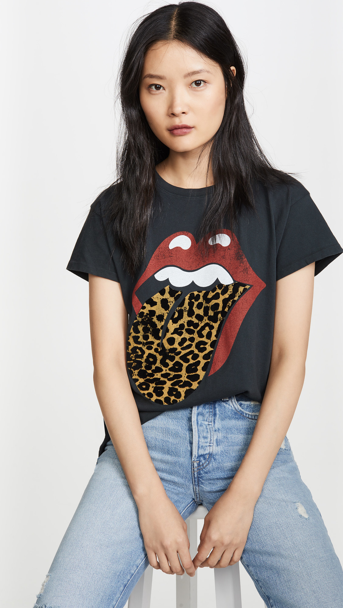a model wearing a black tee with the rolling stones lips and tongue logo but the tongue is leopard print