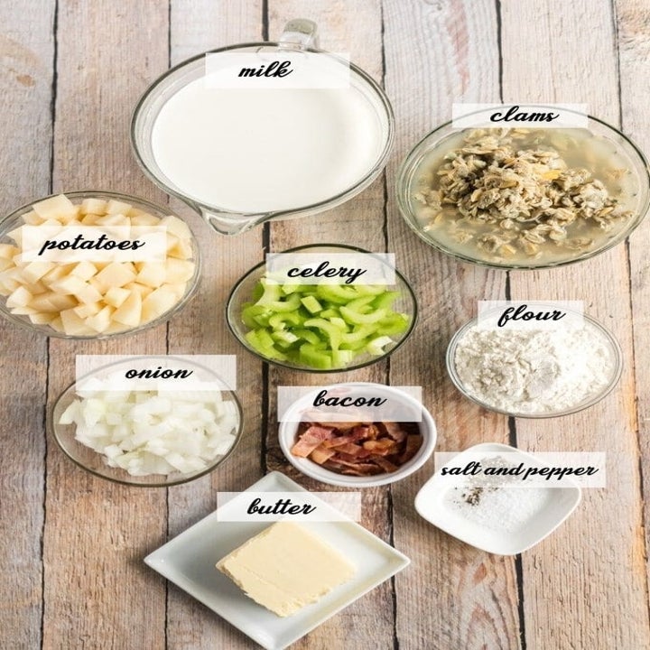 Ingredients for clam chowder on a table, including chopped raw clams, celery, onion, potato, flour, butter, and more.