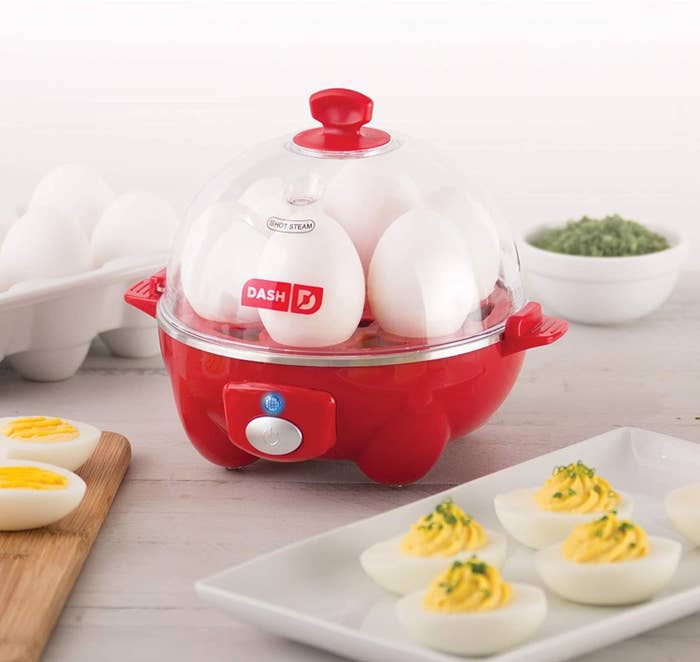An egg cooker with six eggs sitting inside of it with the lid on
