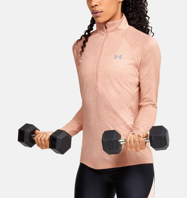 Model exercise with dumbells while wearing a peach-coloured pull over
