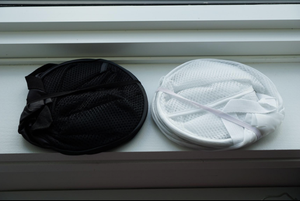 A reviewer image of two white and black collapsed hampers