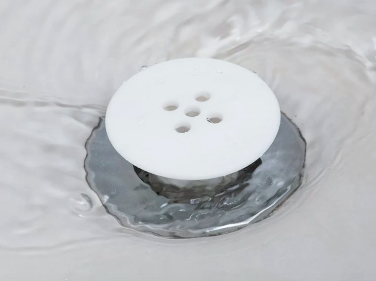 white Tubshroom sticking up out of a shower drain while letting water freely drain