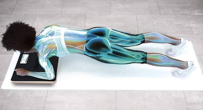 A model uses an interactive Plankboard while working out indoors