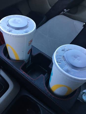 Reviewer's picture of the console organizer holding two McDonald's cups 