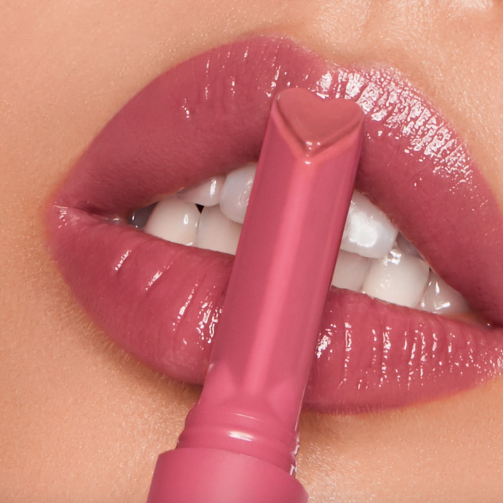 Close-up of lips, showing off juicy, shiny, and rosy pink color and the gloss stick