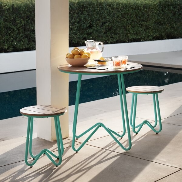 poolside with minimalist three-piece set with table and two stools