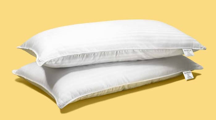 stack of two bed pillows on yellow background