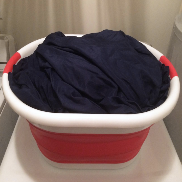 the red and white basket with clothes inside