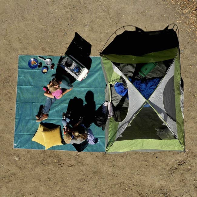 Overhead shot of the blue mat with two people sitting on it and plenty of room for their stuff