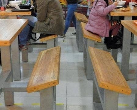 Tables in a mall food court with angled benches