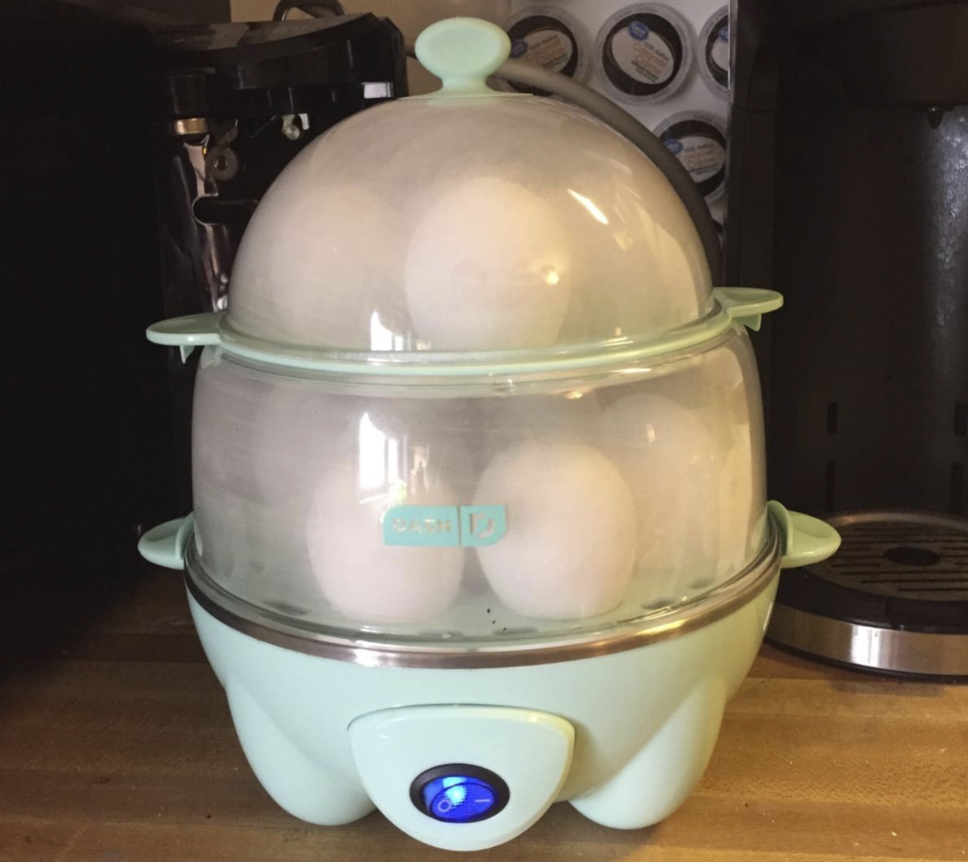 An egg cooker with two tiers that hold six eggs each and a single button for powering on and off