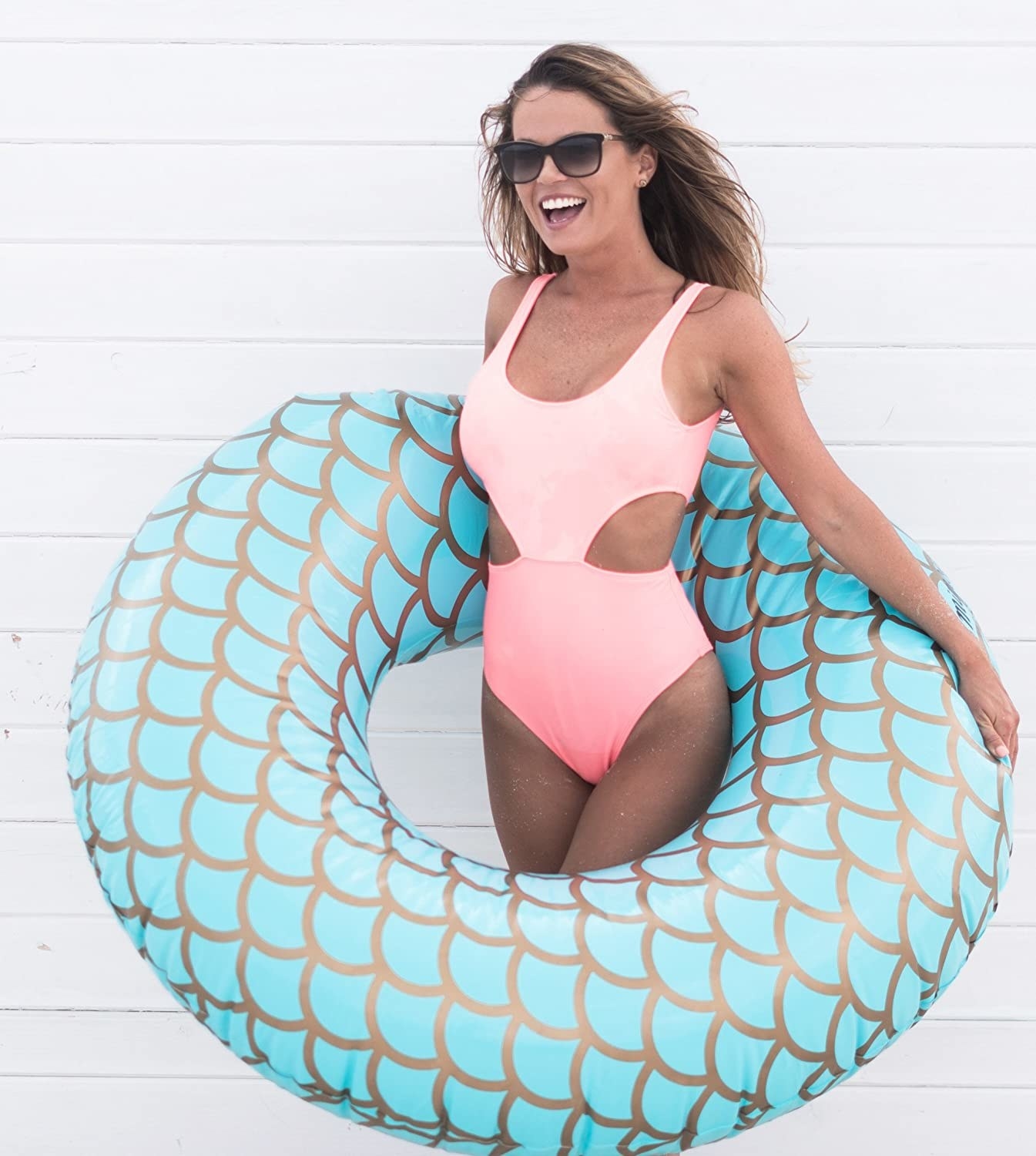 A model wearing the graphic fish scale-patterned pool float