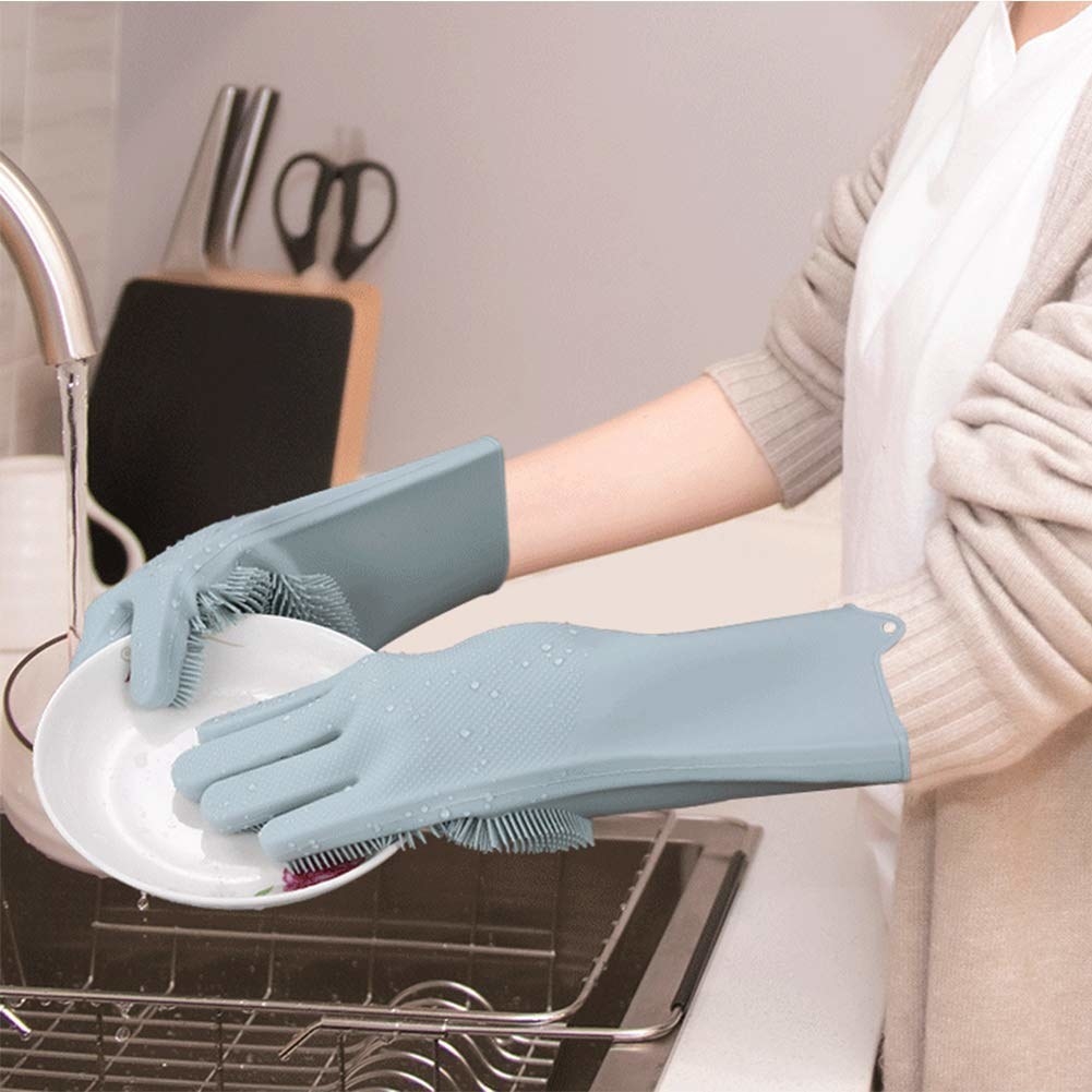 A woman washing a plate while wearing the gloves