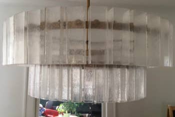 A review image of a modern chandelier with large, cloudy glass panels 