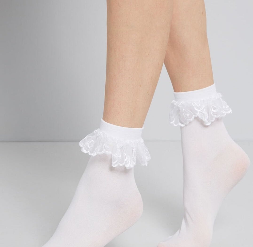 white, dainty socks with frilly eyelet fabric hanging around the top ankle area