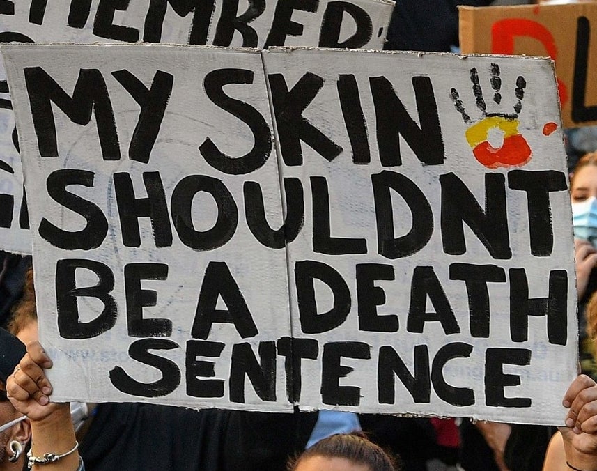 A protest sign reads &quot;My skin shouldn&#x27;t be a death sentence&quot;.
