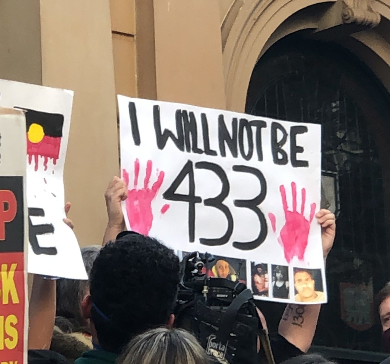 A protest sign reads &quot;I will not be 433&quot;.
