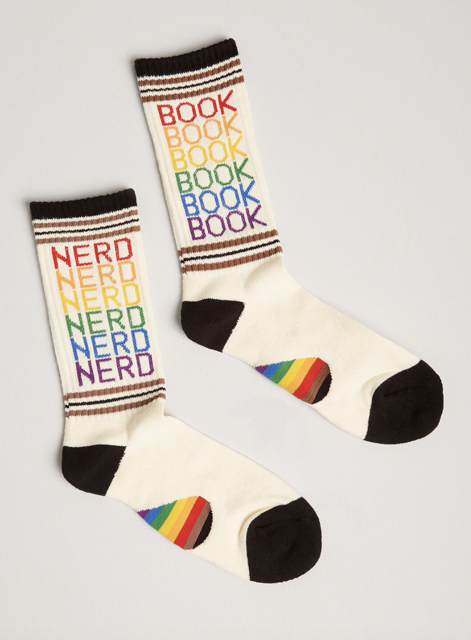 A pair of white socks with black and rainbow detailing, one of which says &quot;book&quot; six times and the other that says &quot;nerd&quot; six times