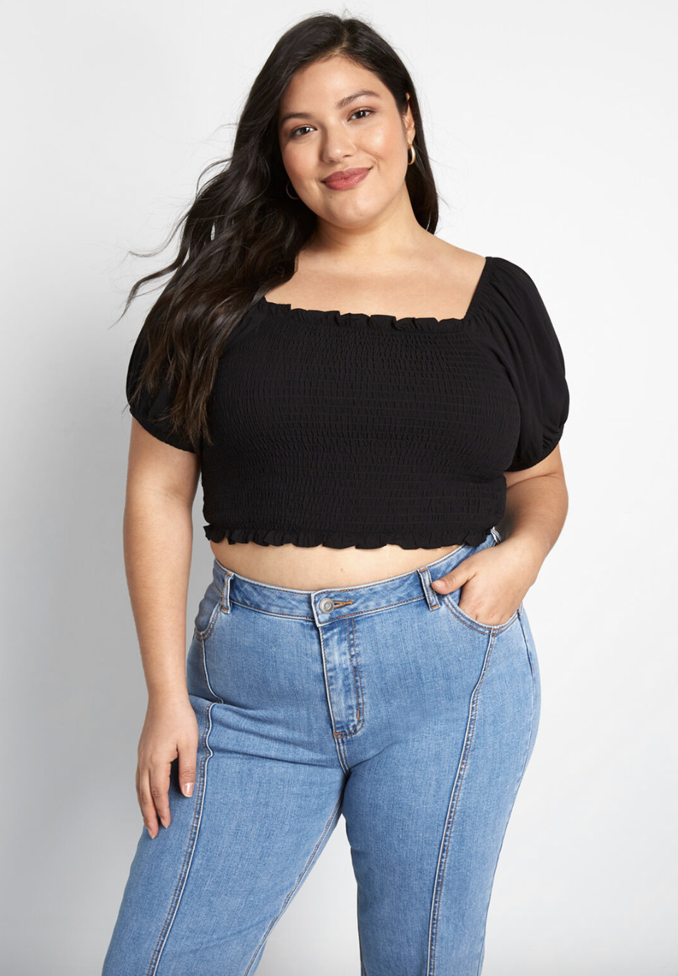 A model in a black smocked crop shirt 