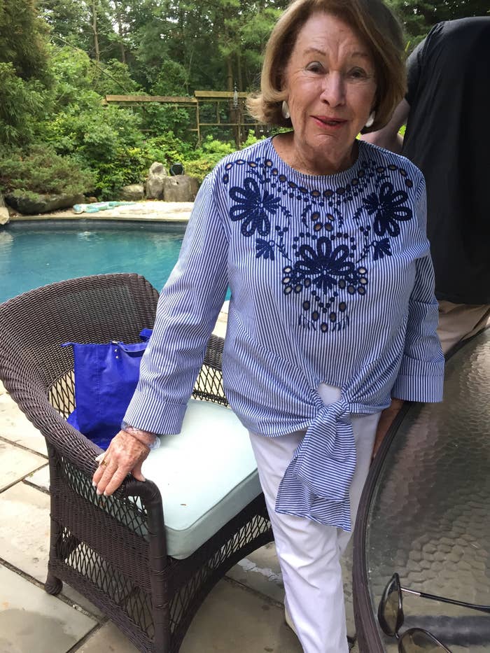 My grandma posing and looking stylish in white jeans and a blue blouse.