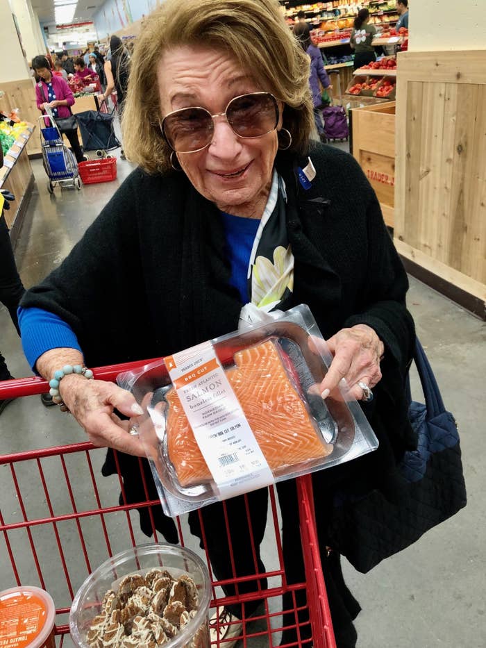 My grandmother grocery shopping at Trader Joe&#x27;s, showing me one of her favorite items, the BBQ-cut salmon.