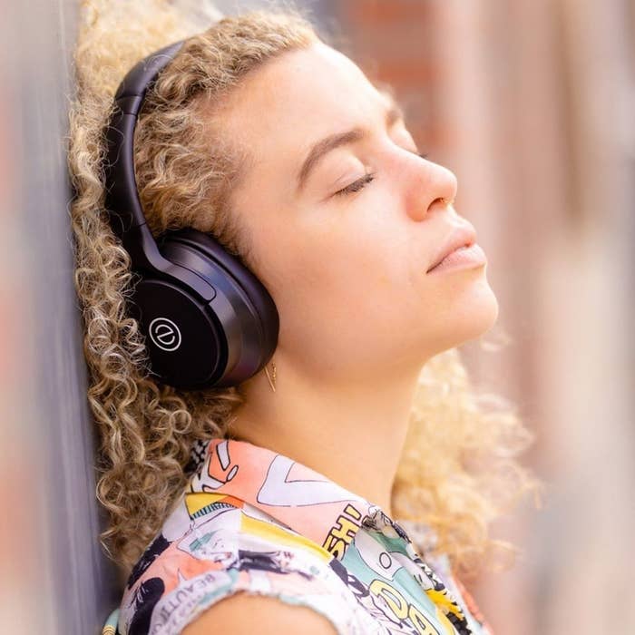 a woman with her eyes closed wearing over the ear headphones