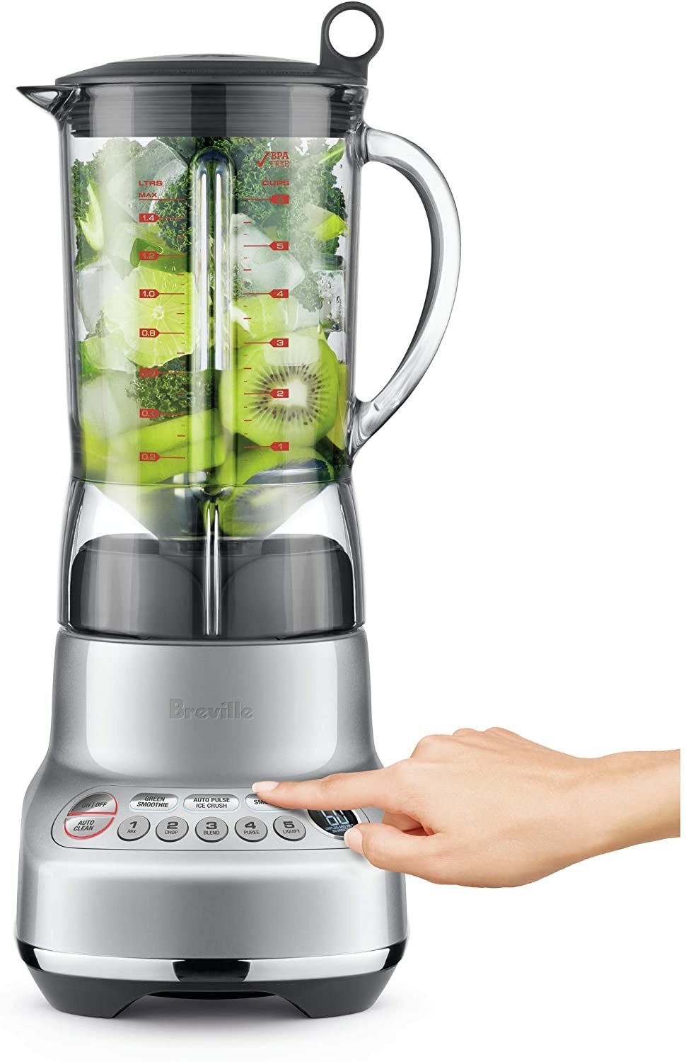 A model&#x27;s hand pressing a button on the metallic silver base of the blender with a jar filled with kiwis