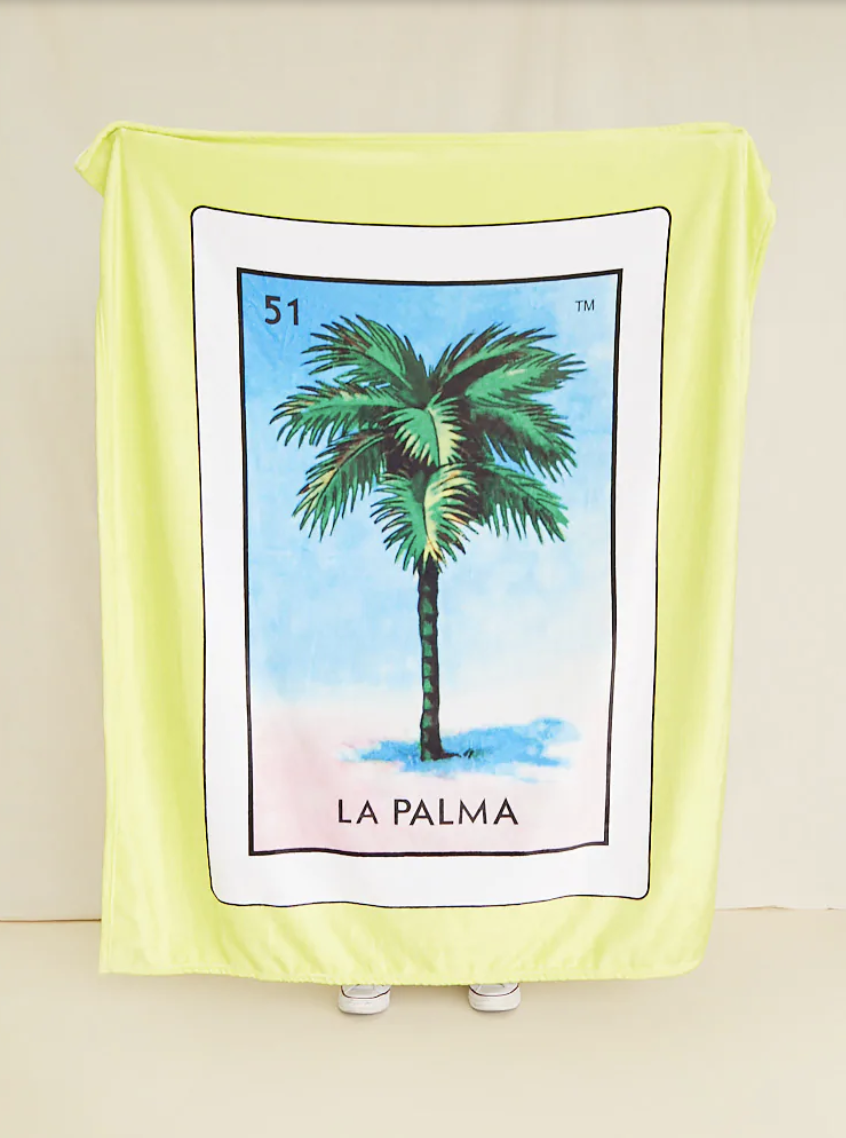 一条黄色的大毯子，中间是一张白色的罗泰利亚牌，上面有一棵棕榈树和“la palma”字样;在它