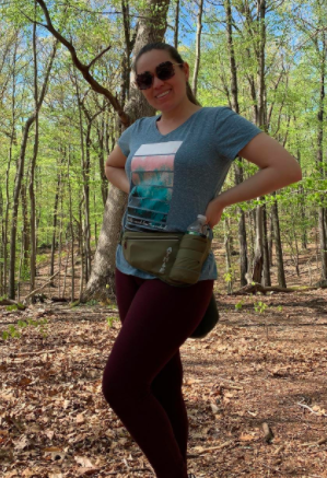 Reviewer wears green running belt on a trail walk in the woods