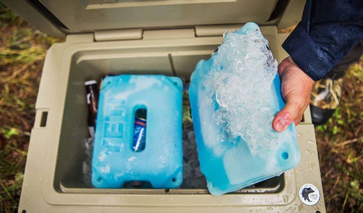 A person putting YETI ice packs into a cooler