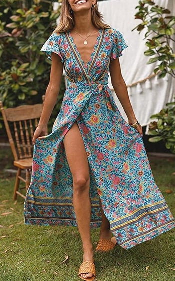 a model in a blue floral maxi length wrap dress