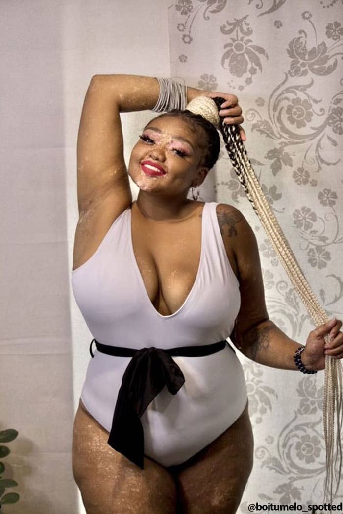 influencer wears white swimsuit with black sash 
