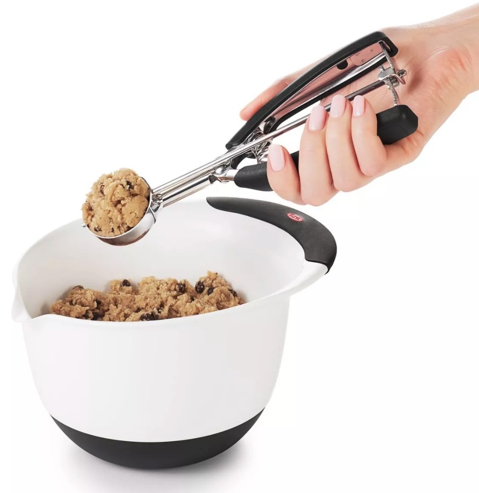 The scooper and a bowl of a cookie dough 