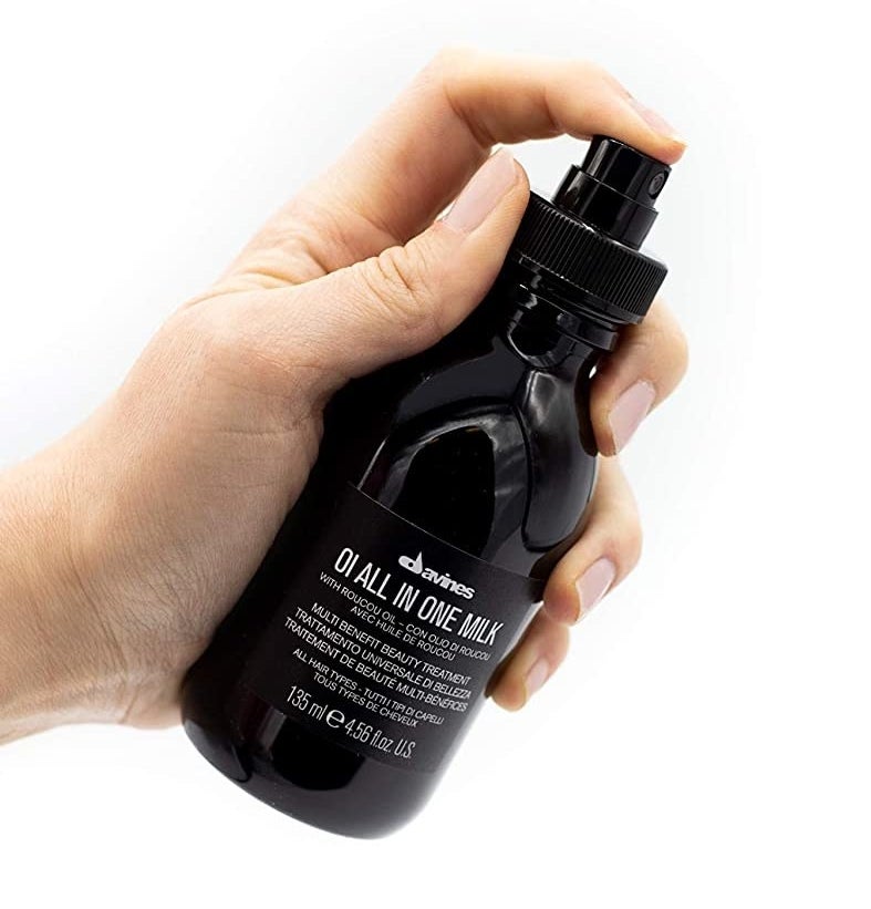 hand holding black spray bottle