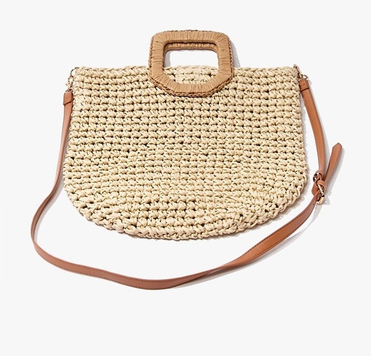 The bag, which has a longer tan strap and a darker tan square handle