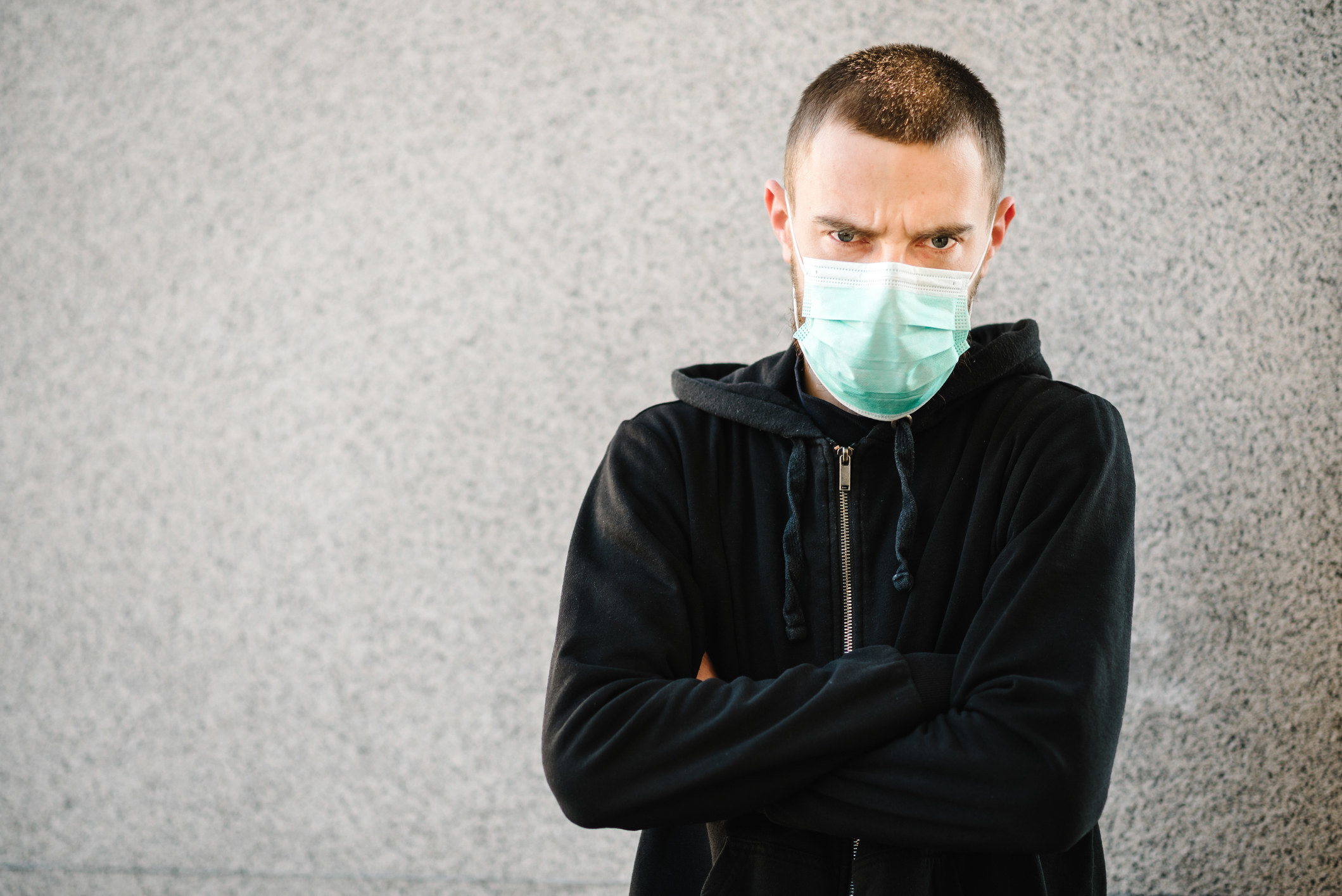 A photo of a man angrily wearing a face mask