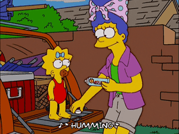 Marge Simpson puts sunscreen on baby Maggie Simpson.