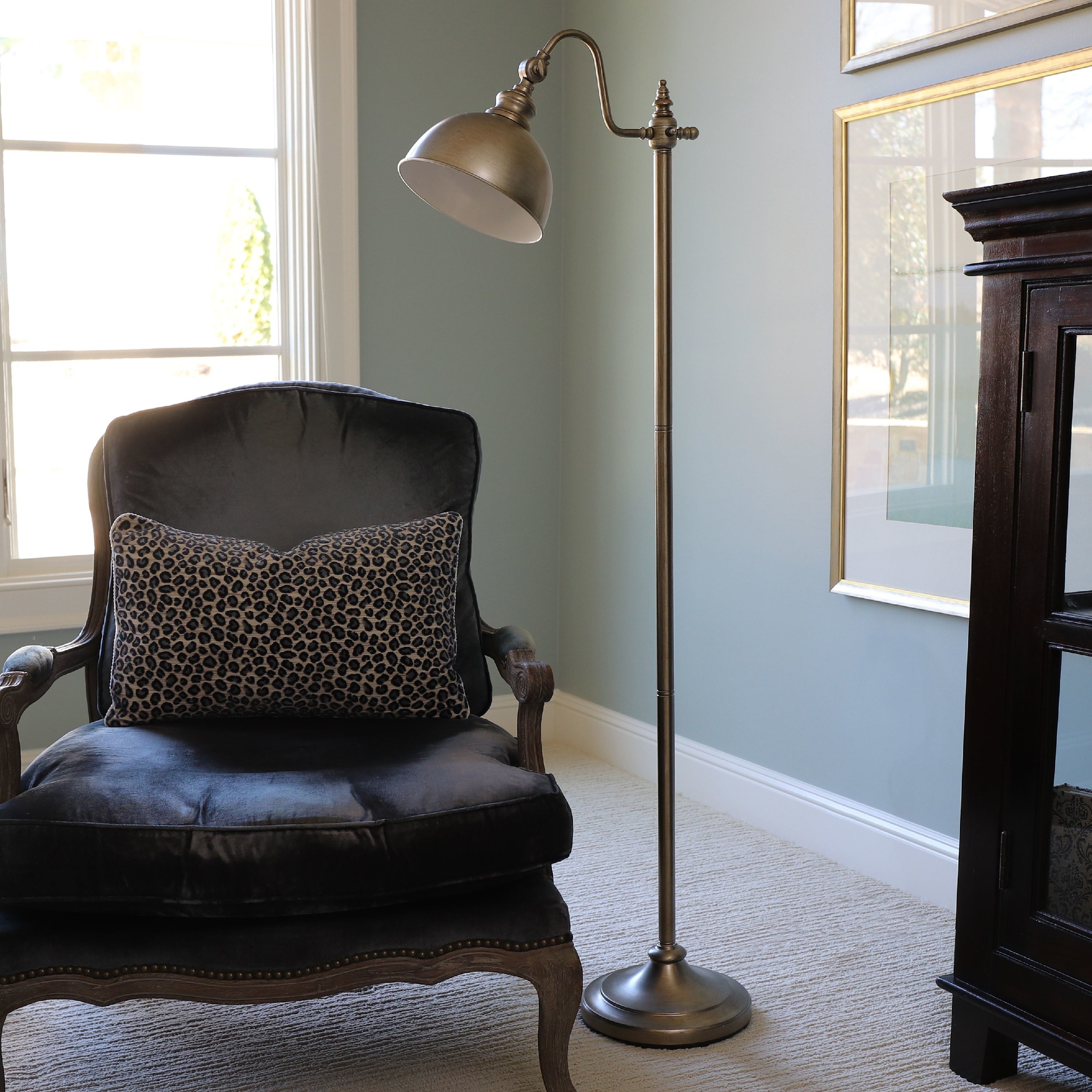 A 56-inch tall brass floor lamp with a round base 