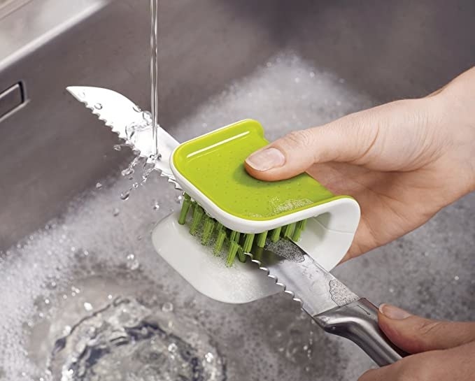 Cutlery cleaning brush used to wash a knife.