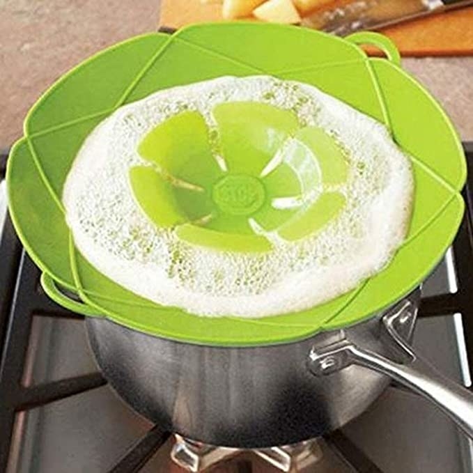 Green coloured silicon pot cover with milk foam on it.