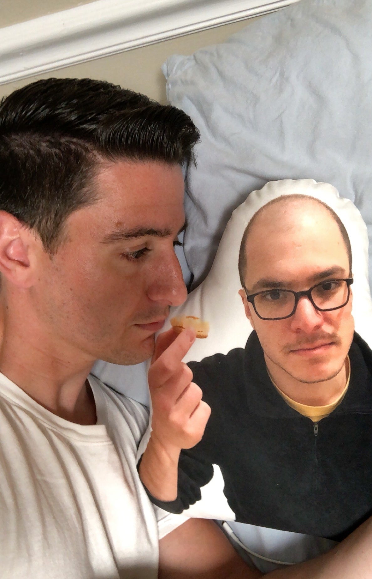 a reviewer cuddling next to a pillow that is rounded to look like the cut out of a person