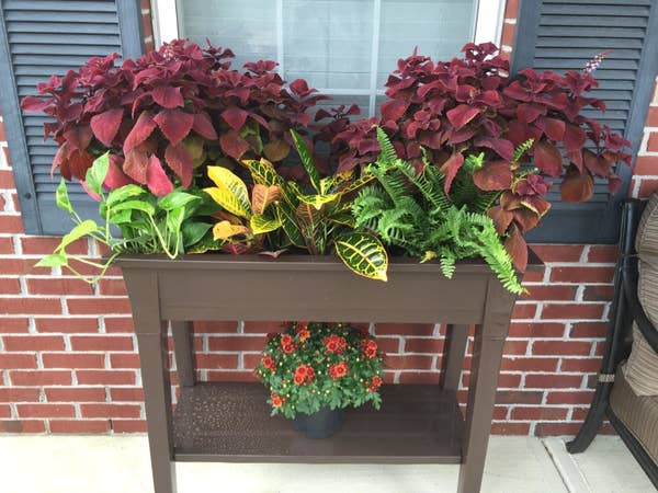 An earth brown planter with a bottom shelf