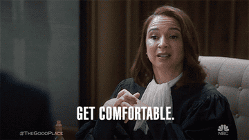 gif of Maya Rudolph in &quot;the good place&quot; saying &quot;get comfortable&quot; and snapping and gesturing to the other main characters who are now wearing comfy clothes