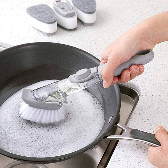 A person scrubbing a pen with the brush.