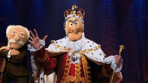 Johnathan Groff as King George III but with Statler&#x27;s head and Waldorf by his side.